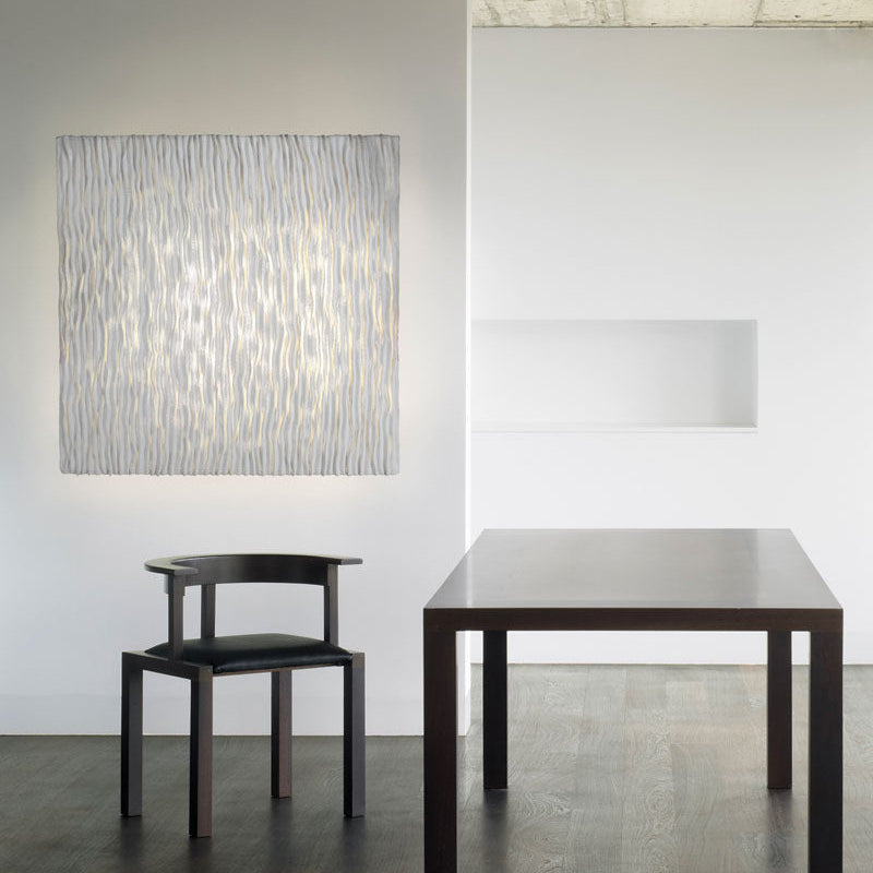 Elegant Planum Wall Lamp with flat geometric form and warm diffused glow, designed by A Emotional Light for contemporary décor.