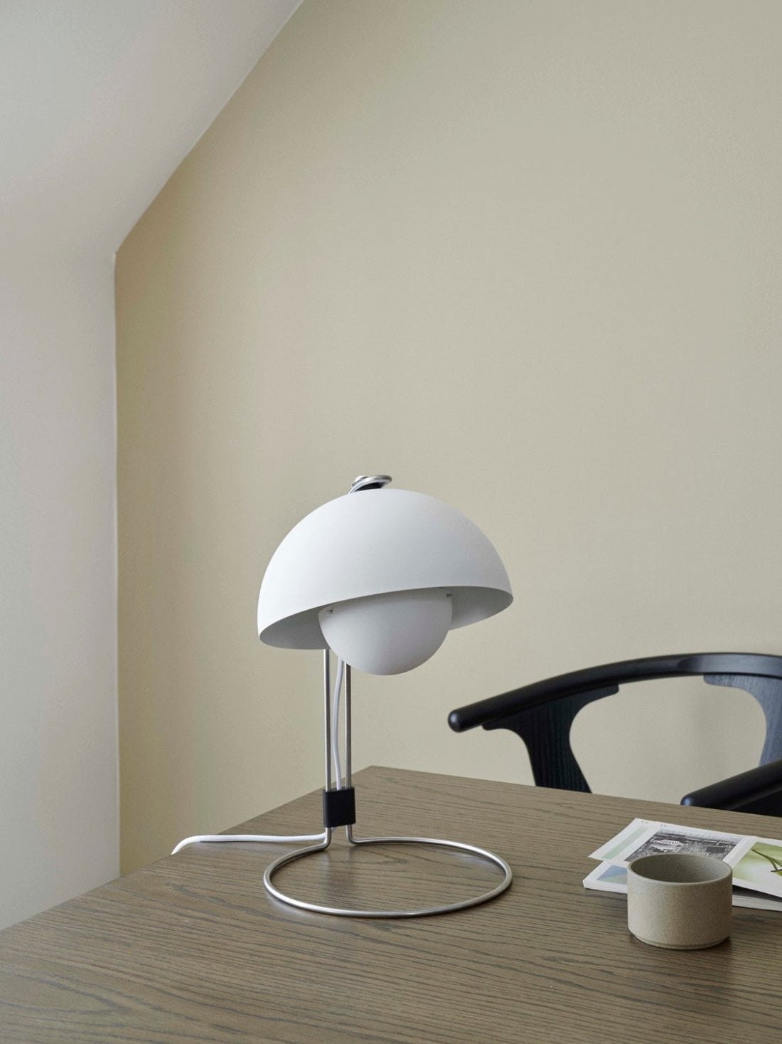 The Flowerpot VP4 by &Tradition in matte white, angled for reading on a nightstand, blending minimalist design with timeless elegance.