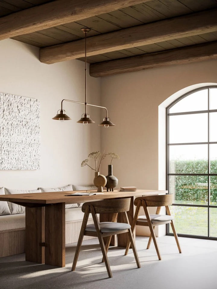 Rustic farmhouse kitchen island with hanging pendants in wrought iron and glass for warm, cozy lighting.