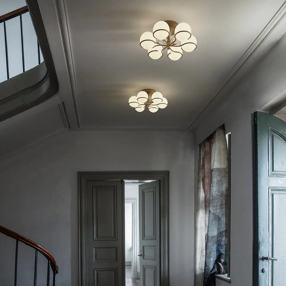 statement chandelier illuminating a high-ceiling foyer with layered warm lighting and modern luxury interiors