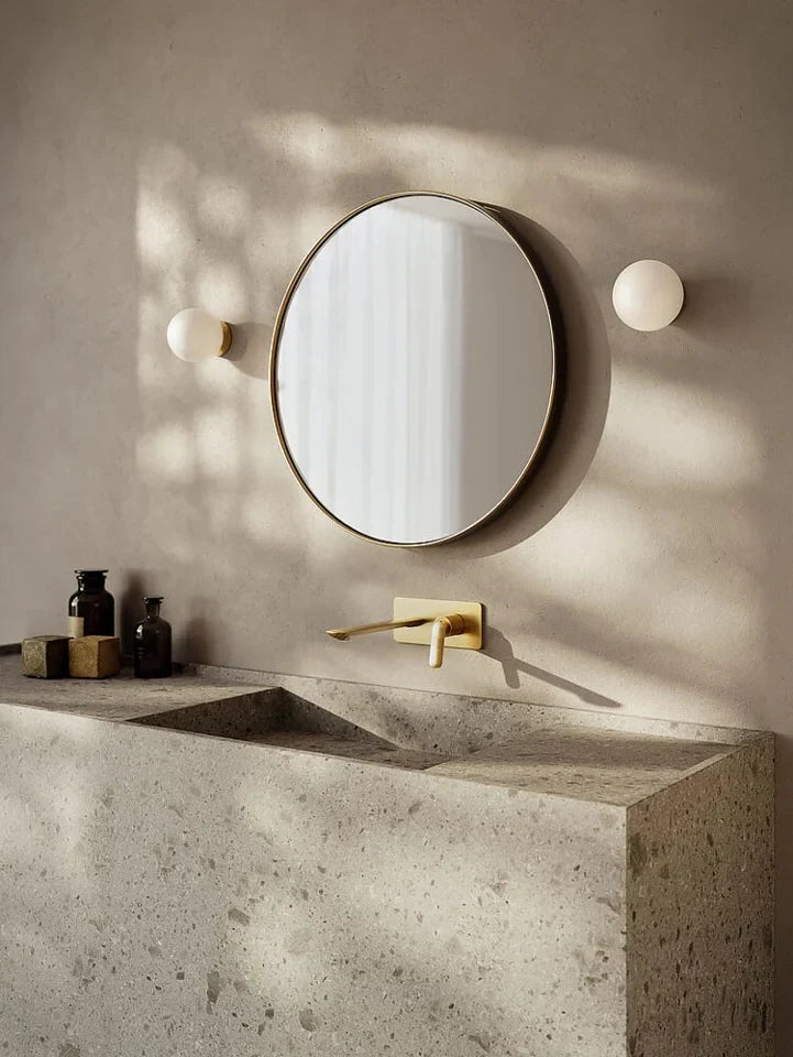 Modern bathroom mirror with vertical wall lamps on both sides providing even, shadow-free lighting for grooming tasks.