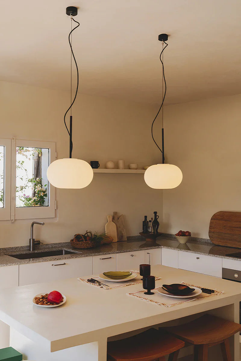 Beautifully lit modern living room showcasing layered lighting with decorative wall lamps, hanging pendants, and luxury designer light fixtures.