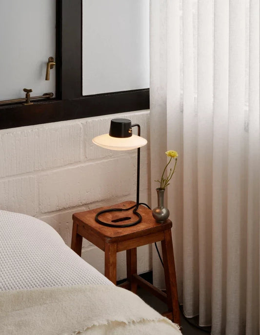Safely concealed light cord along a stylish interior wall using a discreet cable cover and modern decorative lighting fixture.