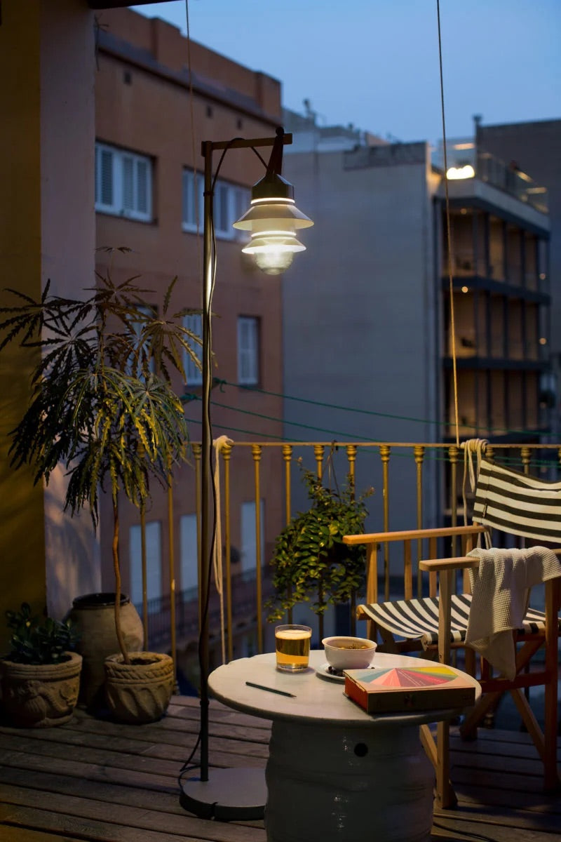 Balcony with warm white wall lamps creating a cozy and inviting evening atmosphere.