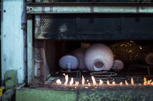 Foscarini handcrafted recycled glass lighting pieces being shaped in a high-temperature furnace, showcasing sustainable craftsmanship and artisanal luxury lighting design for modern interiors.