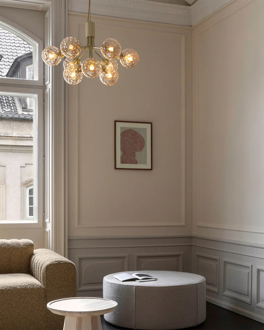 Nuura Apiales 9 chandelier with satin black arms and nine smoked glass shades, designed for modern interiors with elegant, ambient lighting.