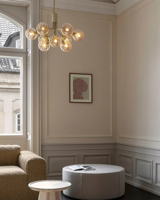 Nuura Apiales 9 chandelier with satin black arms and nine smoked glass shades, designed for modern interiors with elegant, ambient lighting.