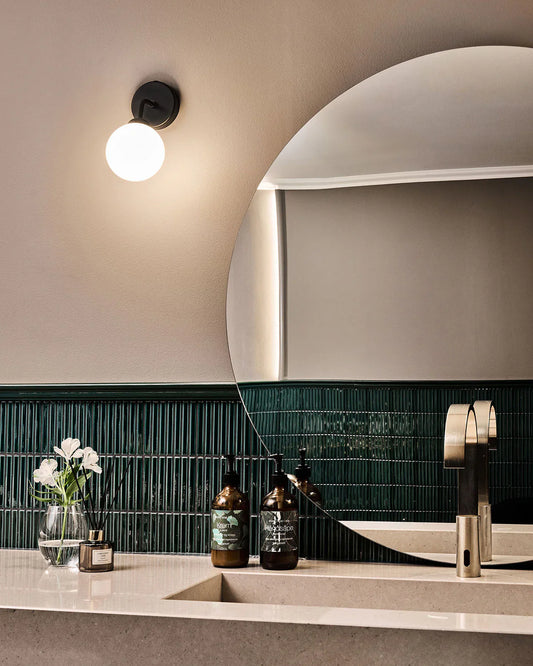 Nuura Wall: a simple and elegant black wall sconce with a white glass diffuser for bathroom lights