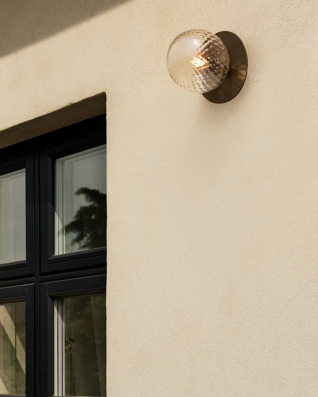 Nuura Liila 1 Outdoor Wall Lamp with bronze finish and clear glass globe, ideal for stylish outdoor wall or ceiling lighting in modern exterior spaces.