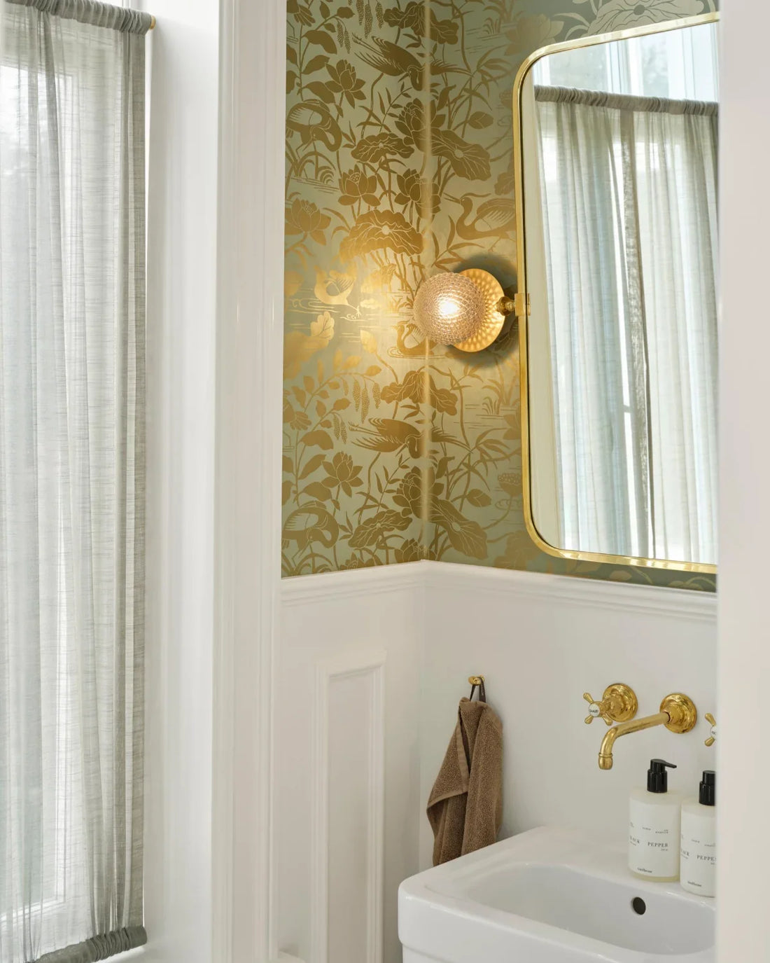 Textured bathroom tile wall illuminated with directional wall lights and recessed spotlights, highlighting its three-dimensional pattern and surface detail.