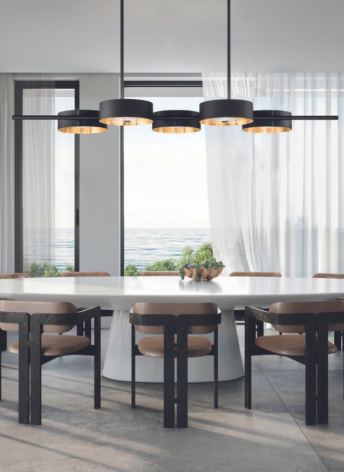 Elegant contemporary dining room featuring a sculptural linear chandelier above a long dining table, with premium European lighting and sophisticated interiors.