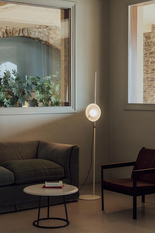 Ambient floor lamps illuminating a sophisticated living room with soft layered lighting instead of traditional overhead ceiling lights.