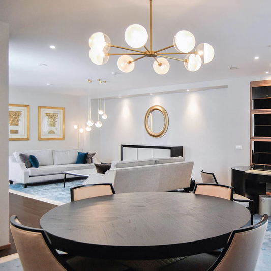 Luxury living room featuring a perfectly scaled statement pendant light with elegant wall lamps and layered ambient lighting in a contemporary interior.