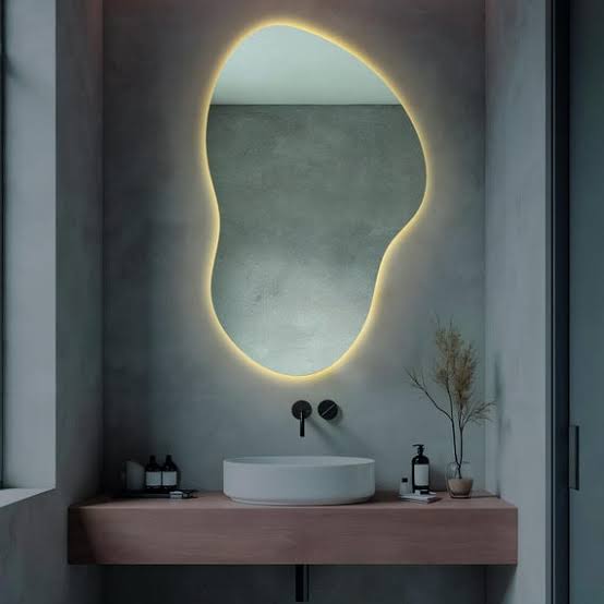 Modern back-lit LED mirror with a soft glowing halo illuminating a luxurious contemporary bathroom or powder room vanity.