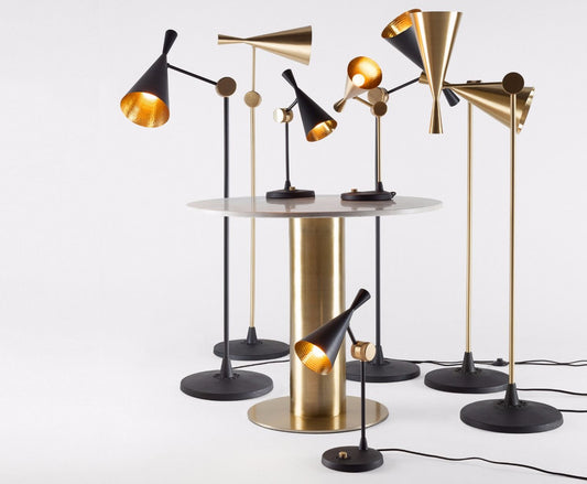 Tom Dixon Beat collection table and floor lamps showcased in luxurious brushed brass and matte black finishes, highlighting premium craftsmanship, sculptural silhouettes, and warm ambient lighting for sophisticated contemporary interiors.