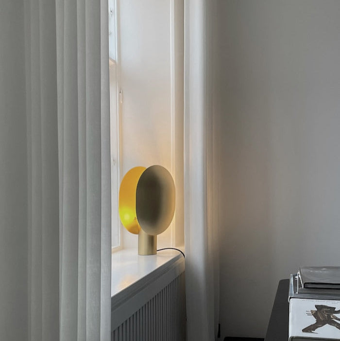 Clam Table Lamp by 101 Copenhagen styled on a side table in a Scandinavian-inspired living room with soft ambient lighting.