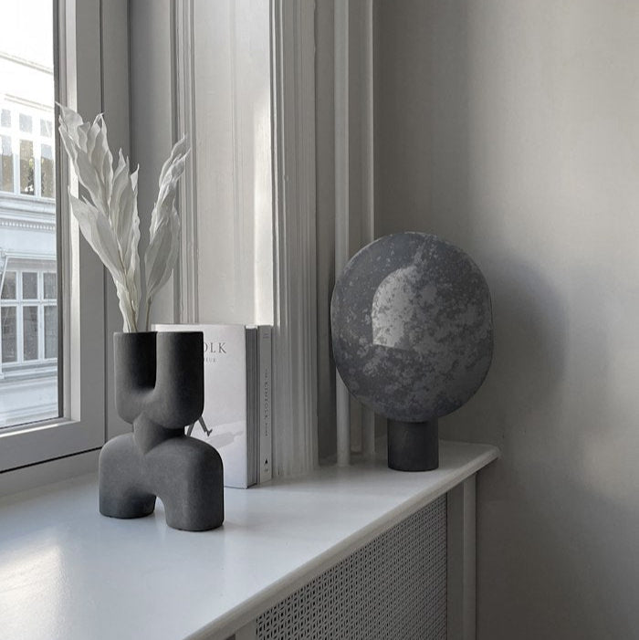 Clam Table Lamp by 101 Copenhagen styled on a side table in a Scandinavian-inspired living room with soft ambient lighting.