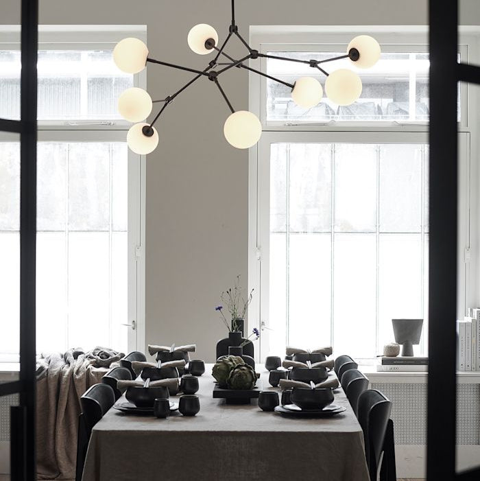 Drop Chandelier Bulb by 101 Copenhagen featuring multiple adjustable arms and exposed bulbs in a minimalist, sculptural design for modern living spaces.