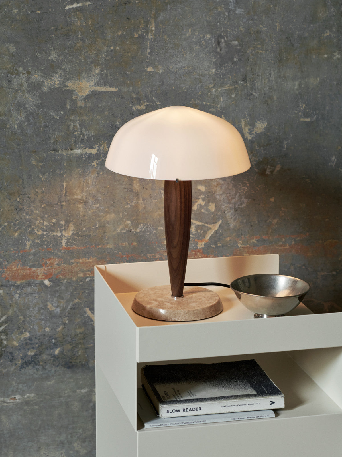 Herman table lamp by &Tradition on a desk, offering warm ambient light in a modern workspace.

