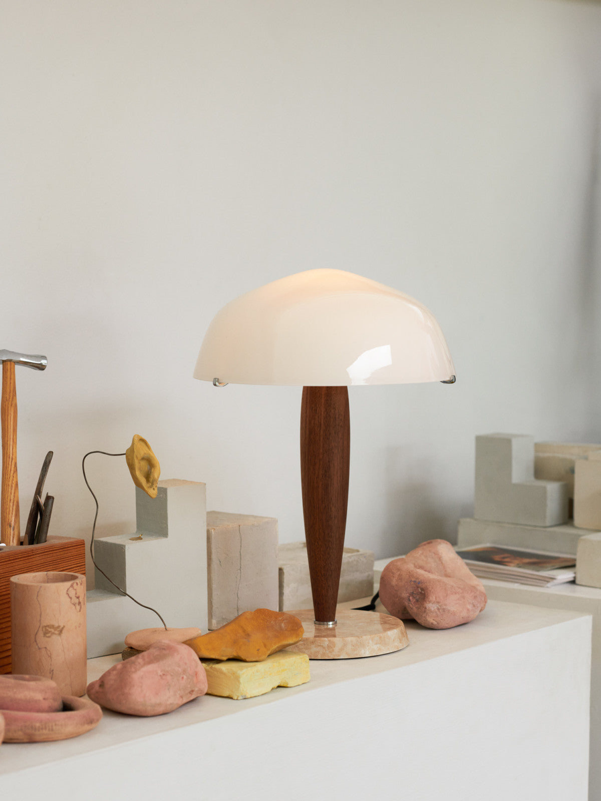 Herman table lamp by &Tradition on a desk, offering warm ambient light in a modern workspace.

