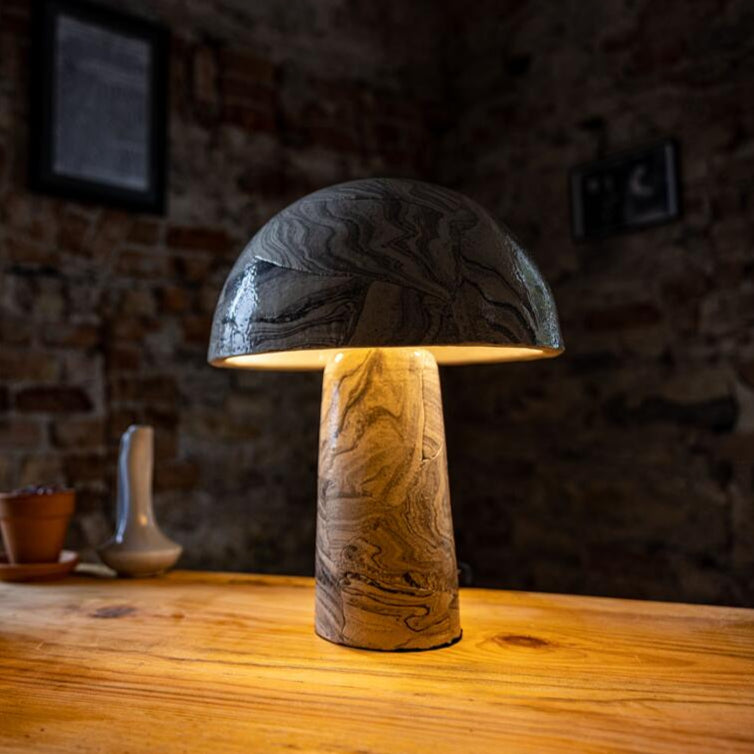 Mushroom-shaped table lamp on a wooden surface with a blurred background