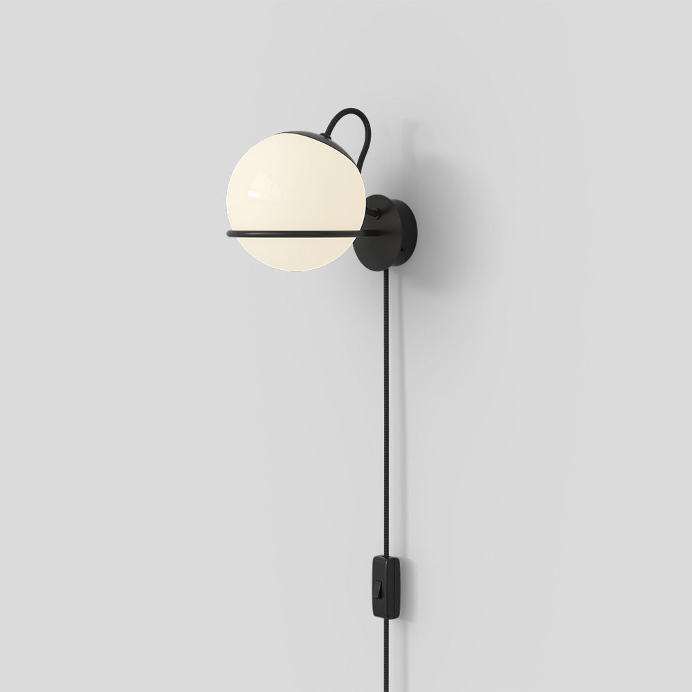 Wall-mounted lamp with a spherical white bulb and black fixture on a light gray background

