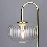 Modern lamp with glass shade and gold fixture on a gray background
