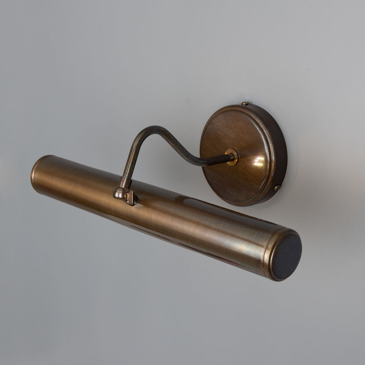 Bronze wall-mounted light fixture on a gray background