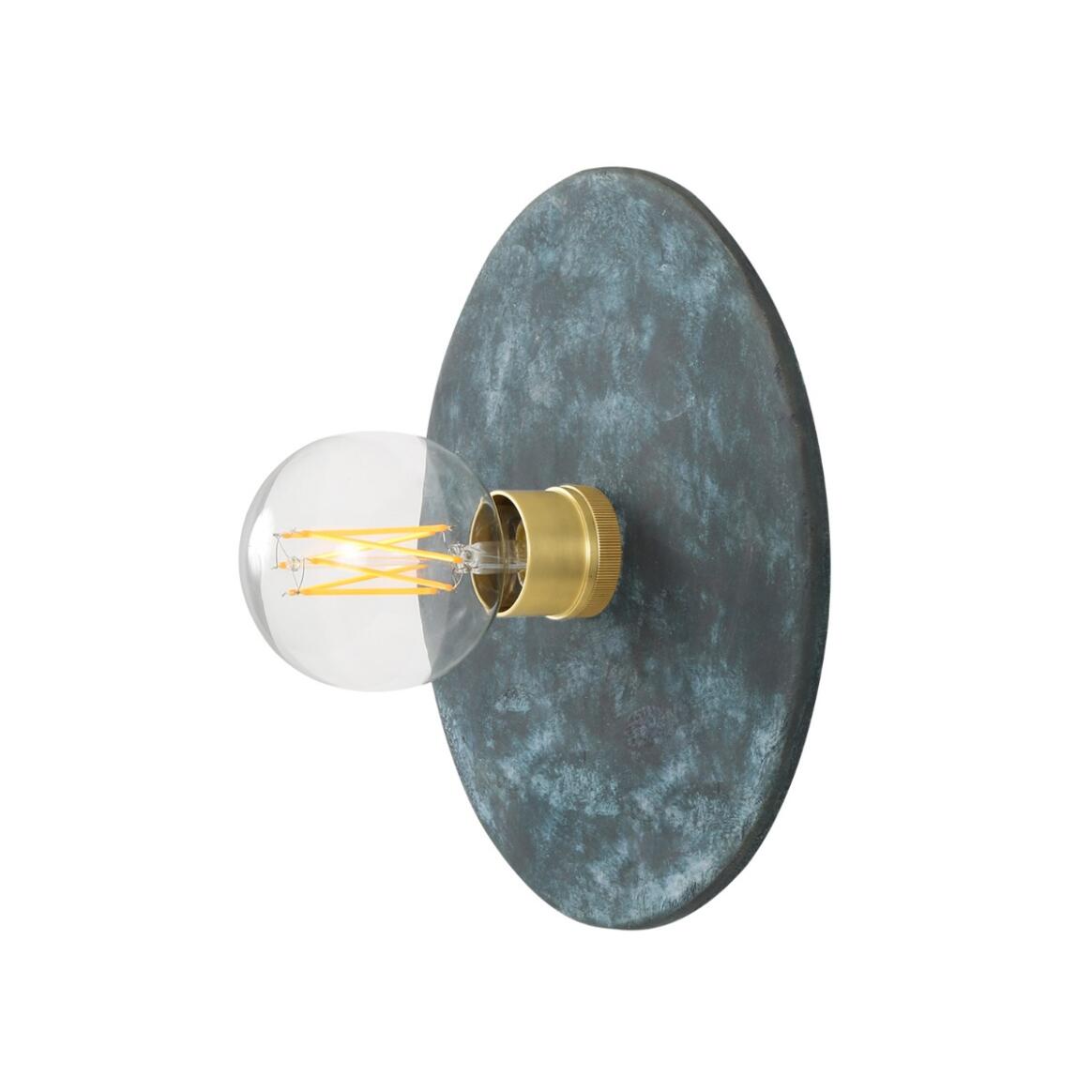Wall-mounted light fixture with a dark blue circular shade and gold base on a white background