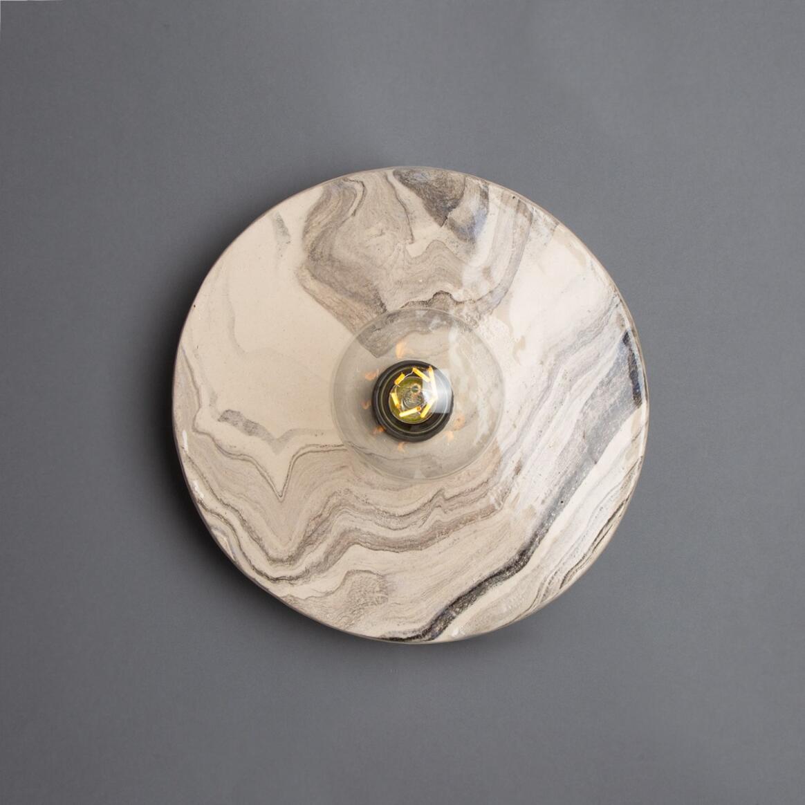 Round marble-patterned wall light fixture on a gray background