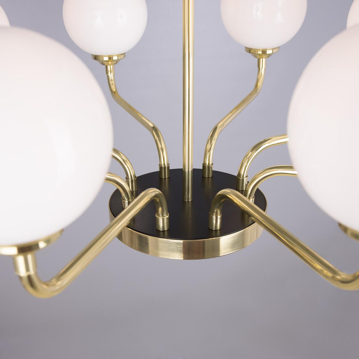 Chandelier with gold fixtures and white spherical lights on a gray background