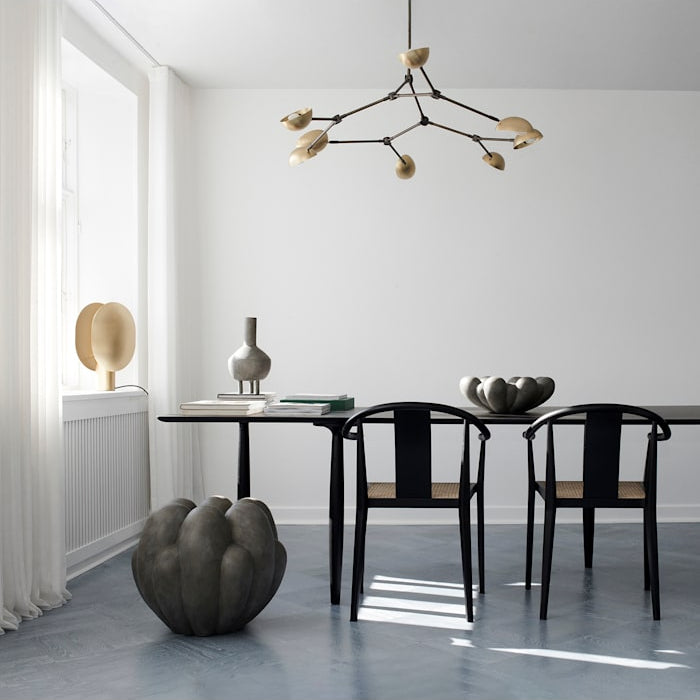 Drop Chandelier positioned above a modern dining table, creating a dramatic focal point with warm ambient light