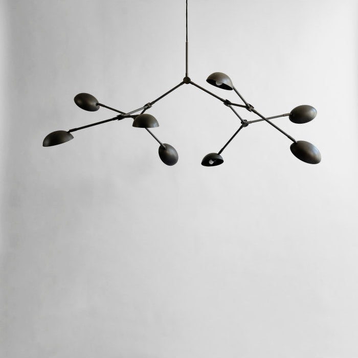 Drop Chandelier positioned above a modern dining table, creating a dramatic focal point with warm ambient light