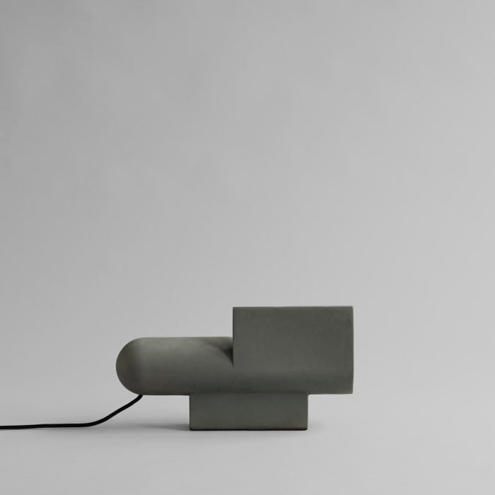 Brutalist Lamp by 101 Copenhagen with its raw textured surface and geometric form placed on a console in a modern setting.