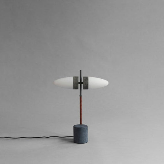 Close-up of the Bull Table Lamp’s textured ceramic base and elegant brass stem with twin opal glass shades.