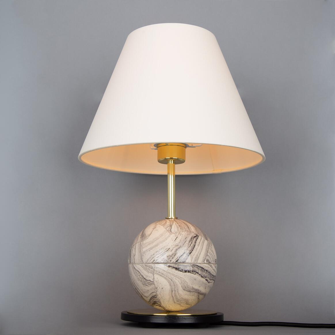 Table lamp with marble base and white shade on a gray background