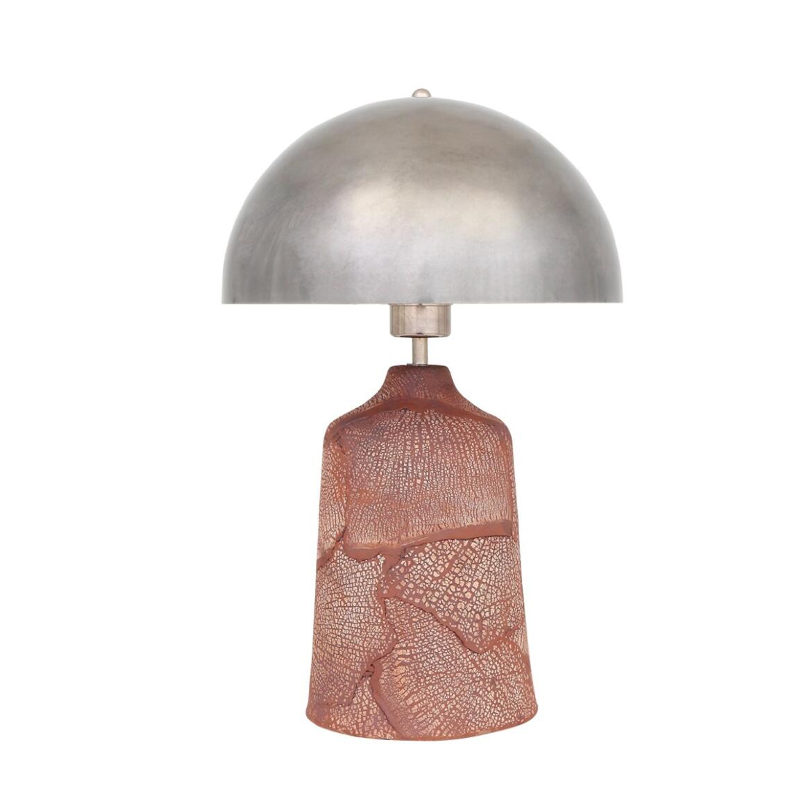 Table lamp with metallic shade and textured pink base on a white background