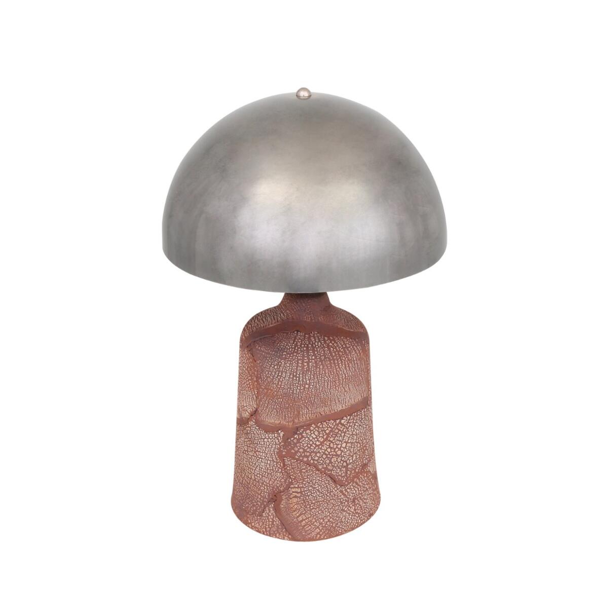 Table lamp with metallic shade and textured base on a white background