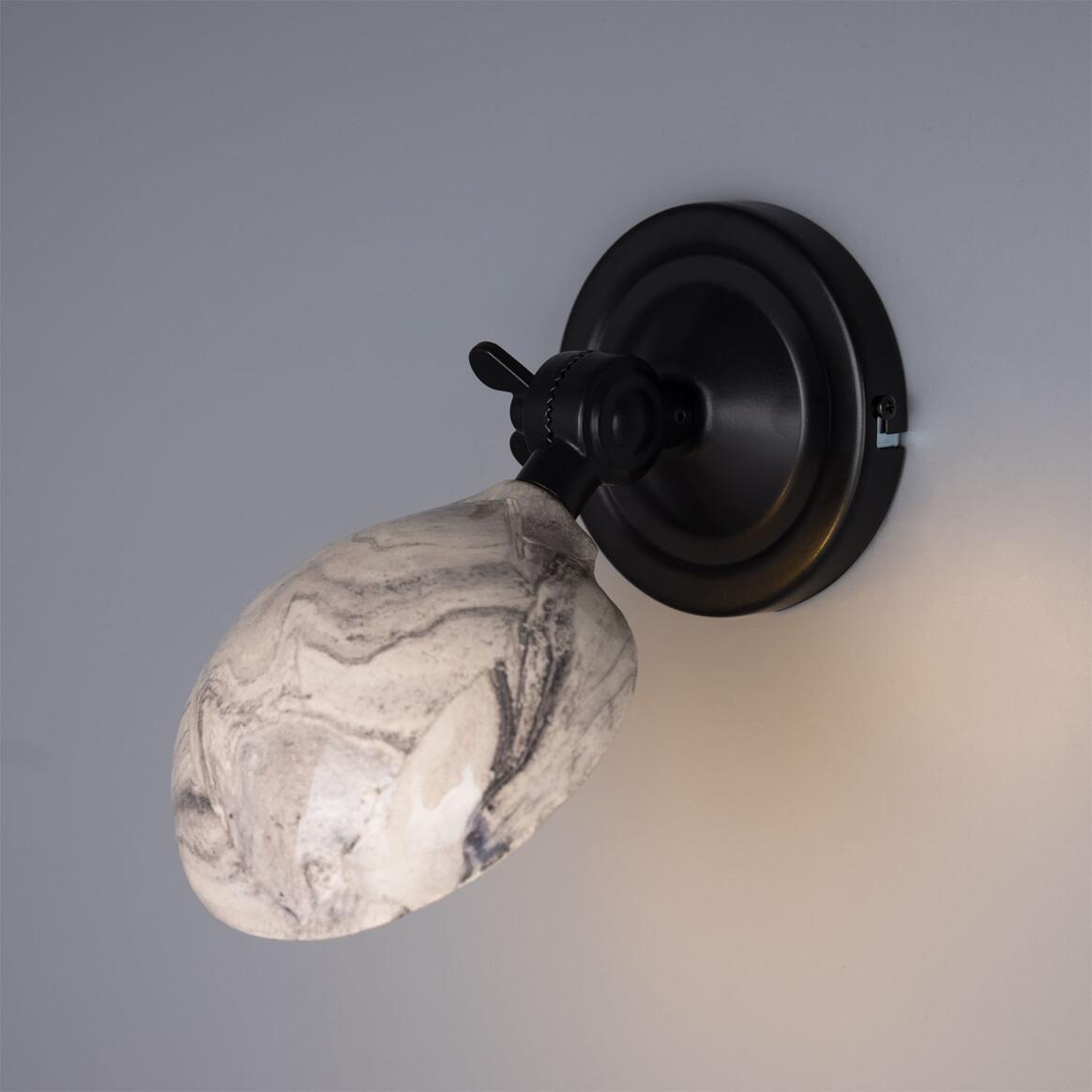 Wall-mounted light fixture with a marble-textured lampshade on a gray background