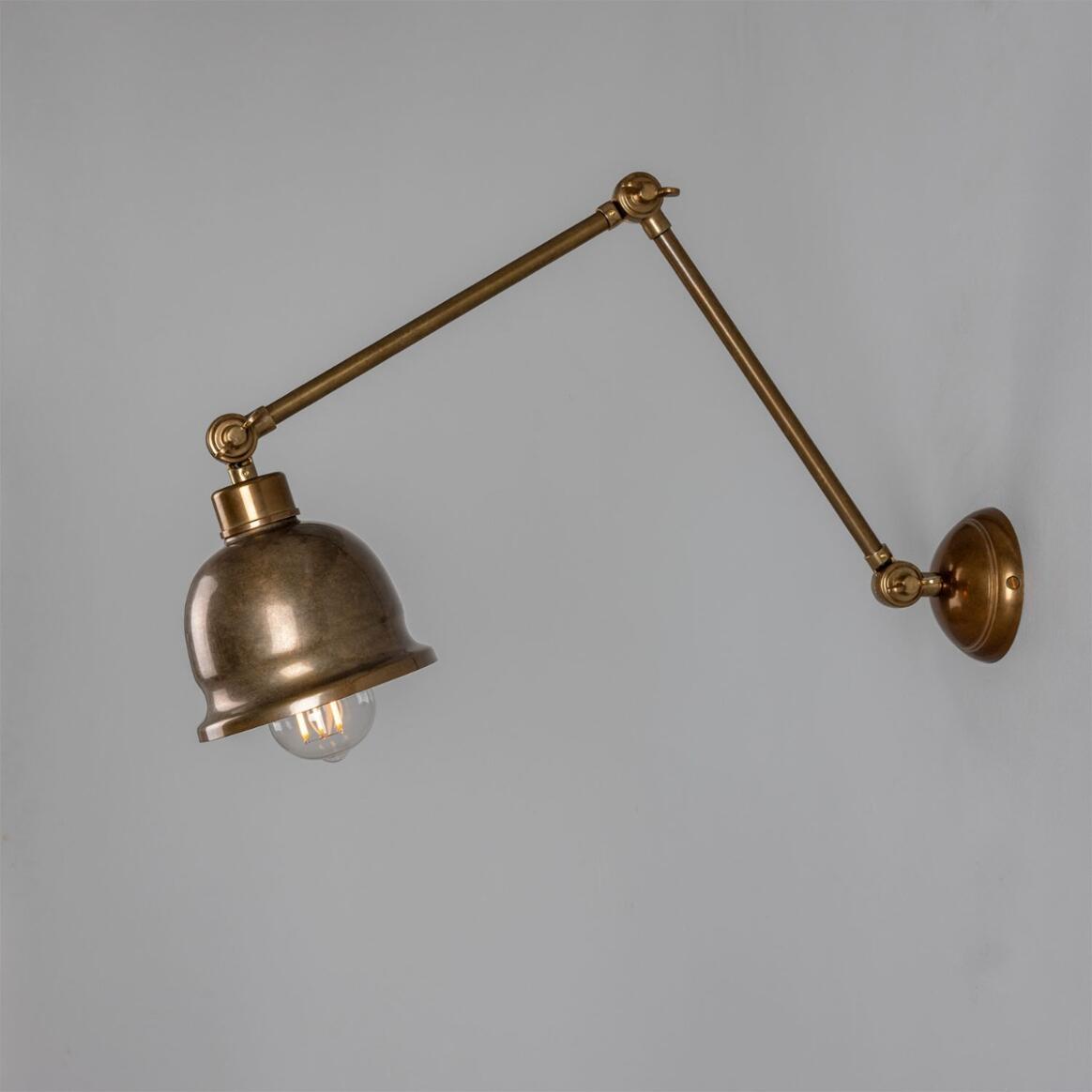 Bronze wall lamp with adjustable arm on a gray background