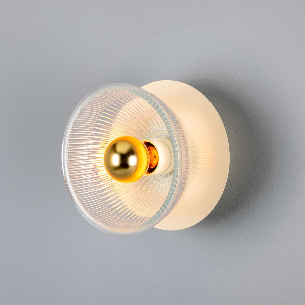 Eclipse Coloured Brass and Prismatic Glass Dish Wall Light by Mullan Lighting with a radiant brass finish and textured prismatic glass for elegant ambient lighting