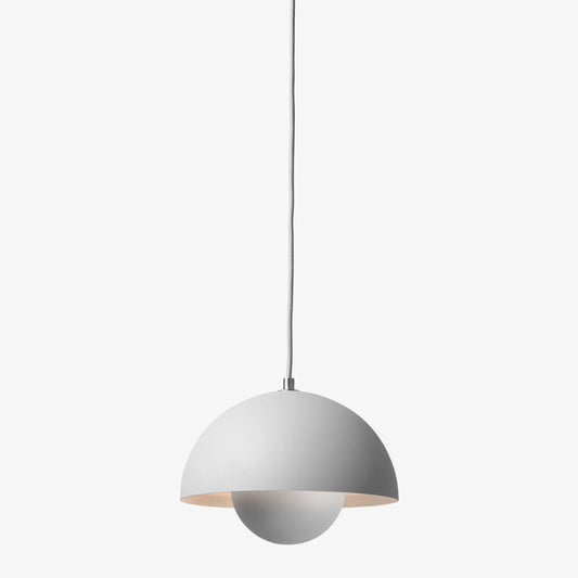 Flowerpot VP1 pendant lamp by &Tradition hanging above a table, adding vibrant retro style.