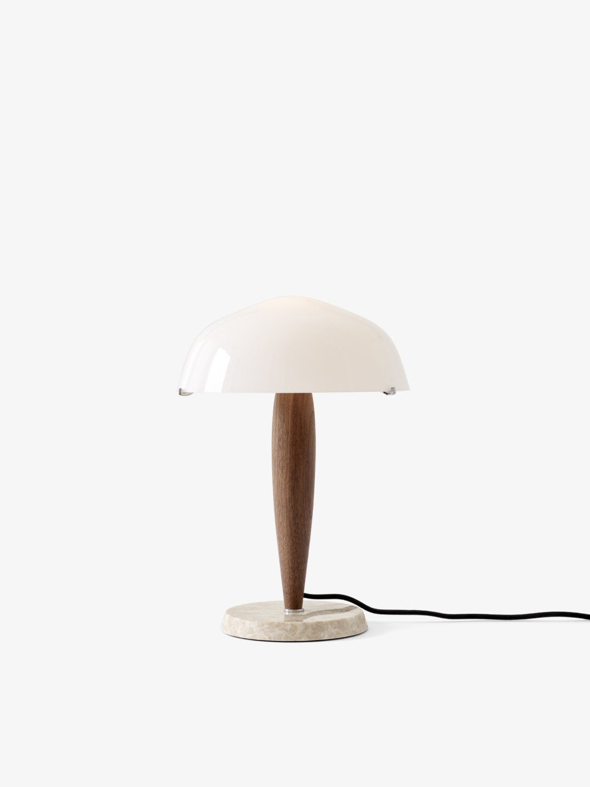 Herman table lamp by &Tradition on a desk, offering warm ambient light in a modern workspace.

