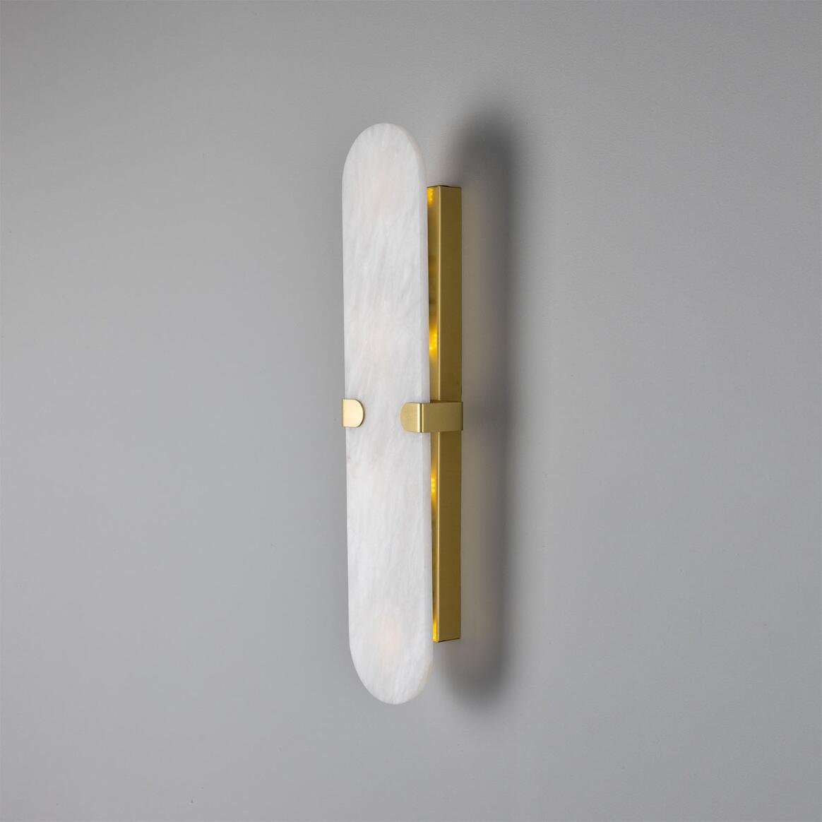 Wall sconce with white marble-like finish and gold accents on a gray background