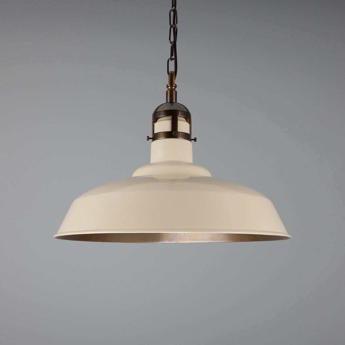 Beige pendant light with bronze accents on a gray background