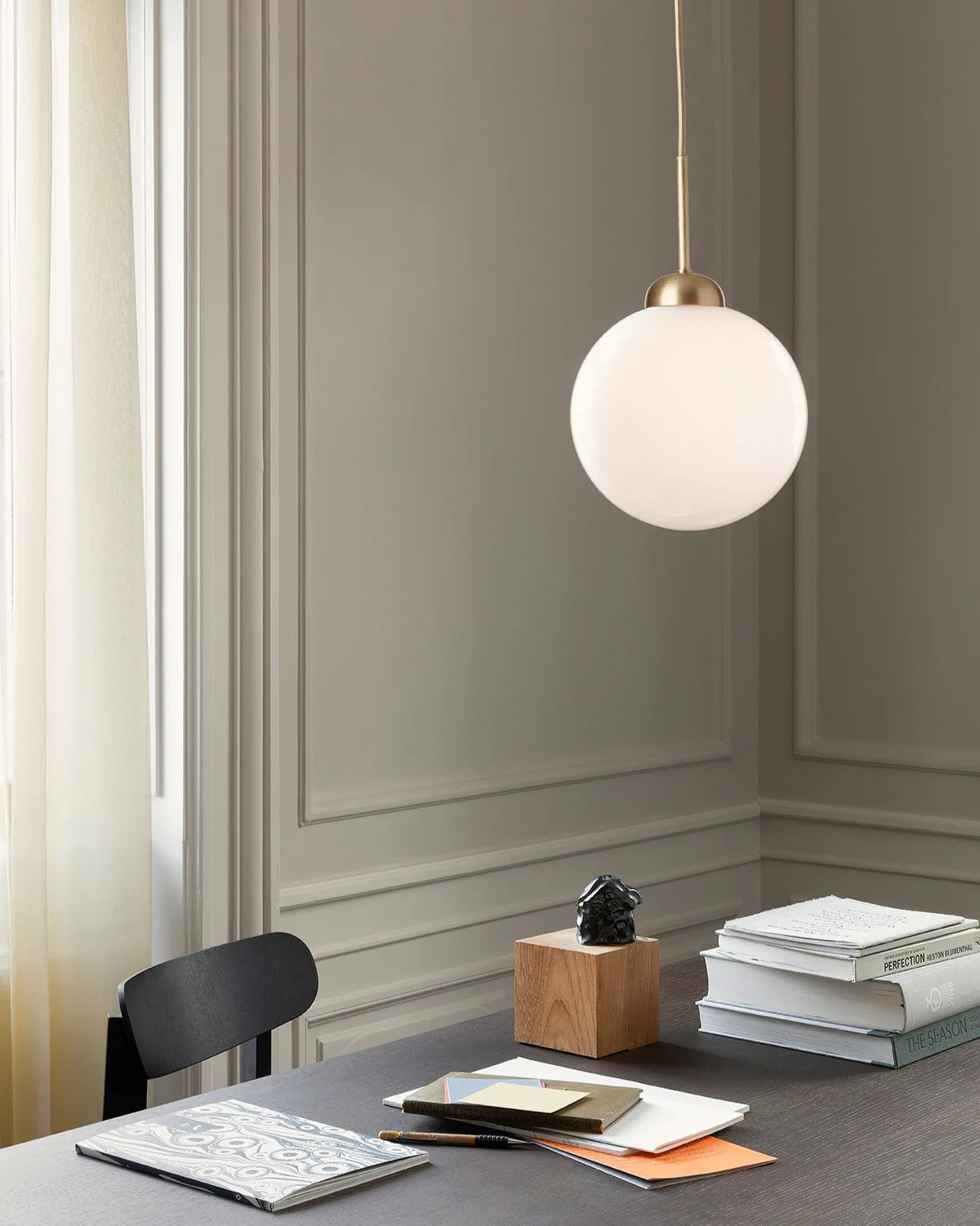 Close-up of Nuura Apiales 1 pendant lamp featuring a hand-blown opal glass shade and elegant brushed brass finish.