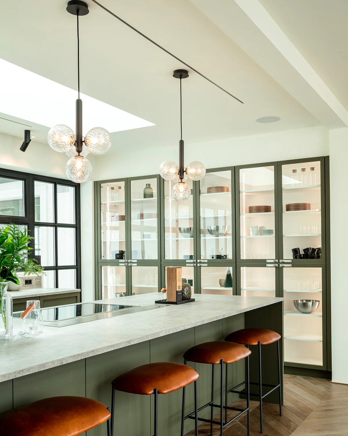 Four-light Scandinavian pendant lamp by Nuura, featuring black frame and clear glass shades for living room , dining room or kitchen lights