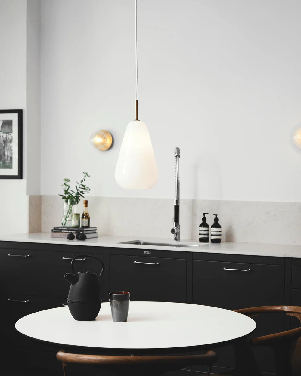 Anoli 1 medium pendant lamp by Nuura with a snowdrop-inspired opal glass shade, gold metal details, and black cord — perfect for Nordic minimalist lighting.