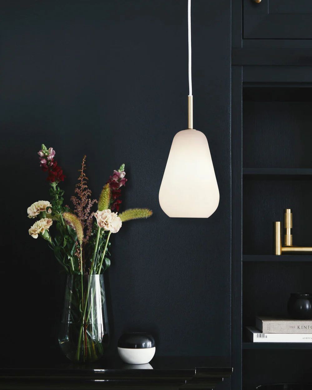 Anoli 1 medium pendant lamp by Nuura with a snowdrop-inspired opal glass shade, gold metal details, and black cord — perfect for Nordic minimalist lighting.