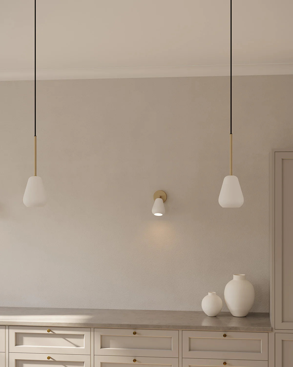 Anoli Spot Pendant by Nuura featuring a white metal teardrop shade, gold suspension, and black fabric cord for modern, focused interior lighting.